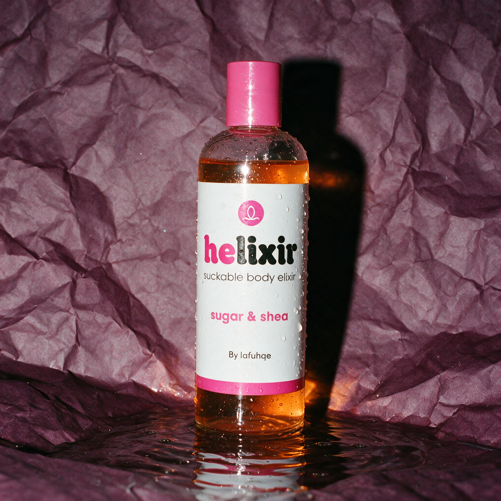 Helixir moisturizing body oil photographed on deep aubergine plum backdrop